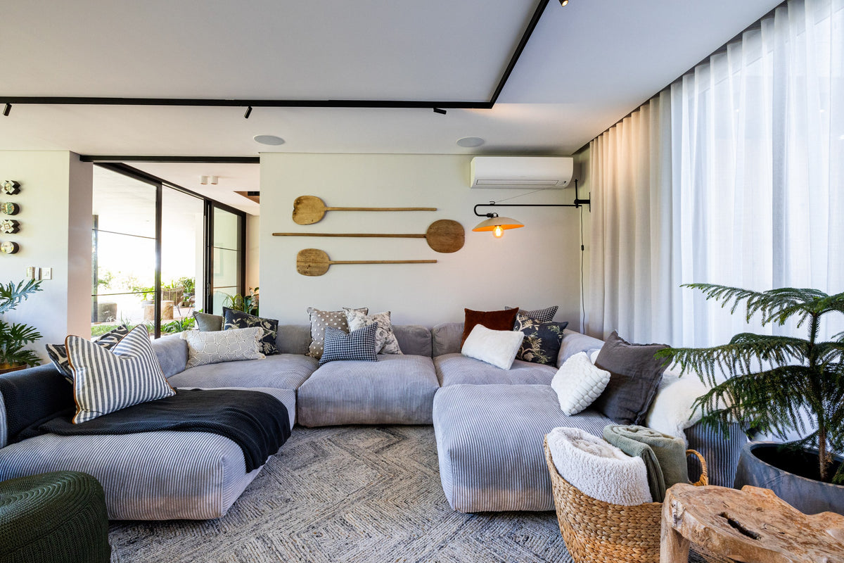 Duvenci Interiors — Lounge with grey sectional sofa and greenery